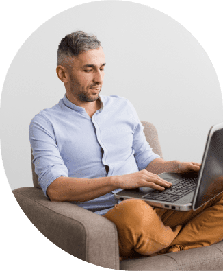 a man sitting in a chair using a laptop