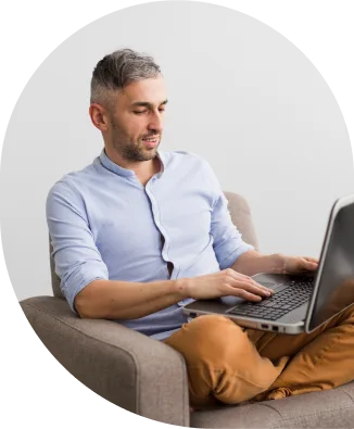 a man sitting in a chair using a laptop